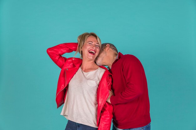 Hombre envejecido besando a mujer sonriente