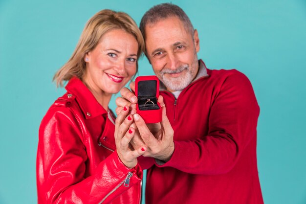 Hombre envejecido y mujer positiva mostrando caja de joyas