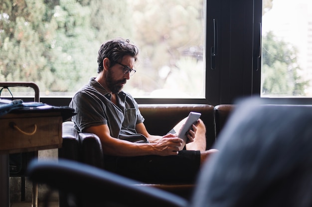 Hombre envejecido con tableta