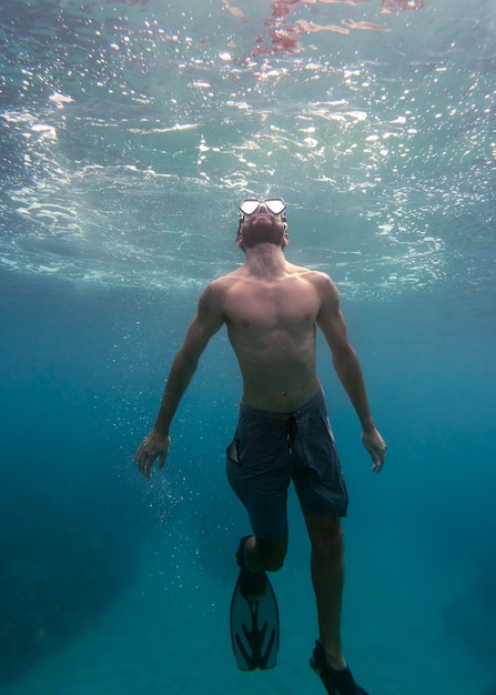 Foto gratuita hombre con equipo de buceo nadando en el océano