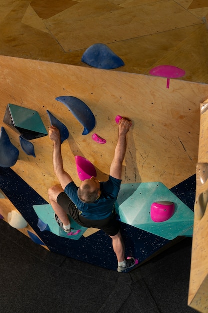 Foto gratuita hombre escalada en roca en el interior de la arena