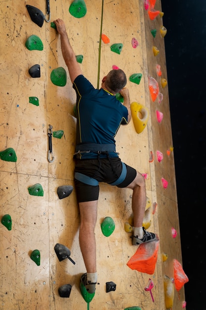 Hombre escalada en roca en el interior de la arena