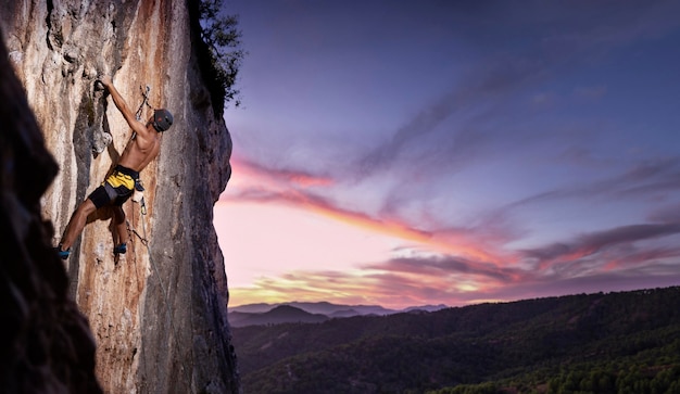 Hombre escalando una montaña con equipo de seguridad