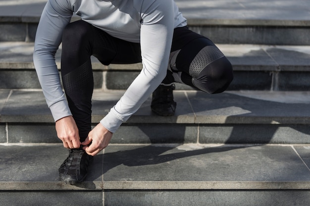 Hombre en las escaleras atando sus cordones