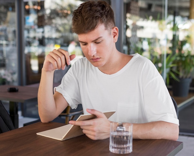 Foto gratuita hombre escribiendo al aire libre en el pub