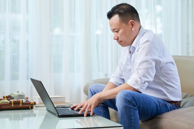 Hombre escribiendo en la computadora portátil