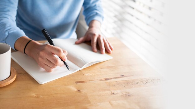 Hombre escribiendo en un diario mientras está en casa en la nueva normalidad