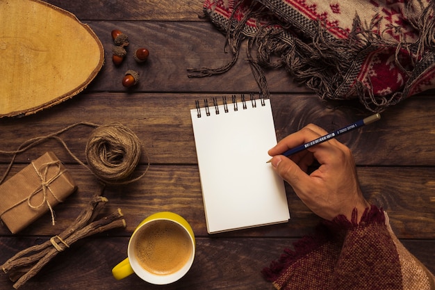 Hombre escribiendo en el elegante lugar de trabajo de otoño