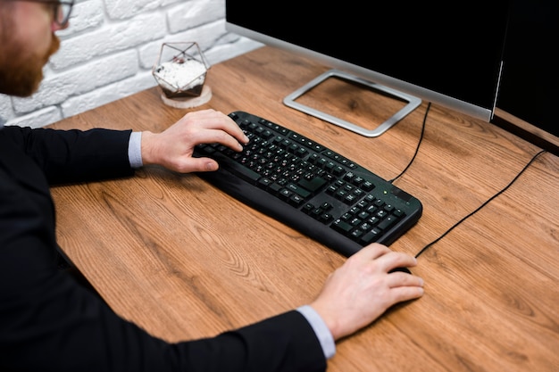 Hombre escribiendo en el teclado de cerca