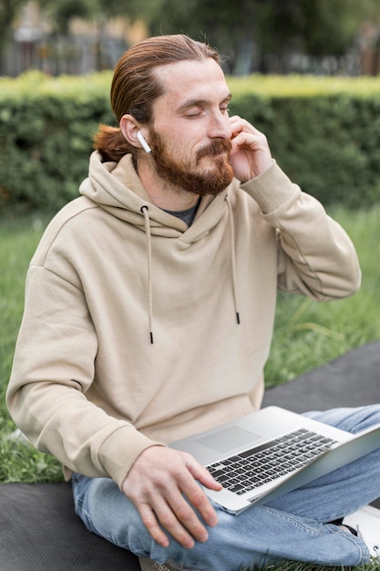 Hombre escuchando música en auriculares al aire libre