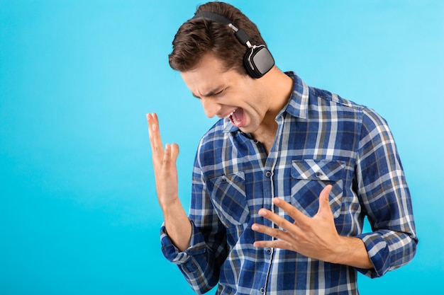 Foto gratuita hombre escuchando música con auriculares inalámbricos divirtiéndose en azul