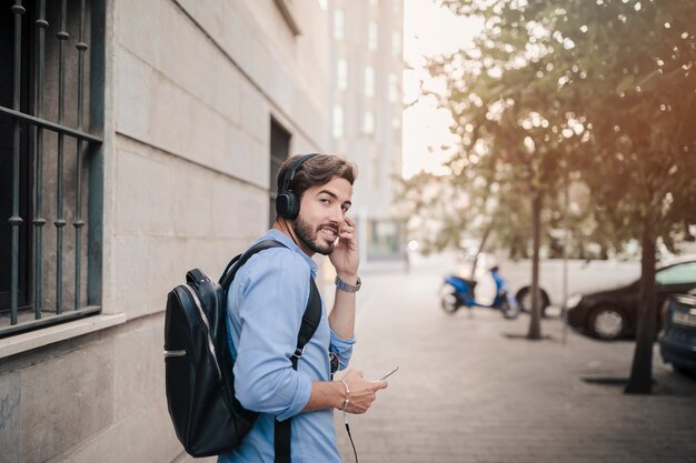 Hombre escuchando música en auriculares mirando a cámara