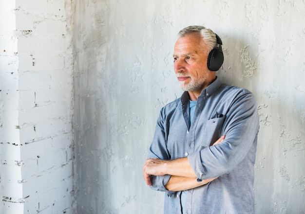 Foto gratuita hombre escuchando música en auriculares mirando a otro lado