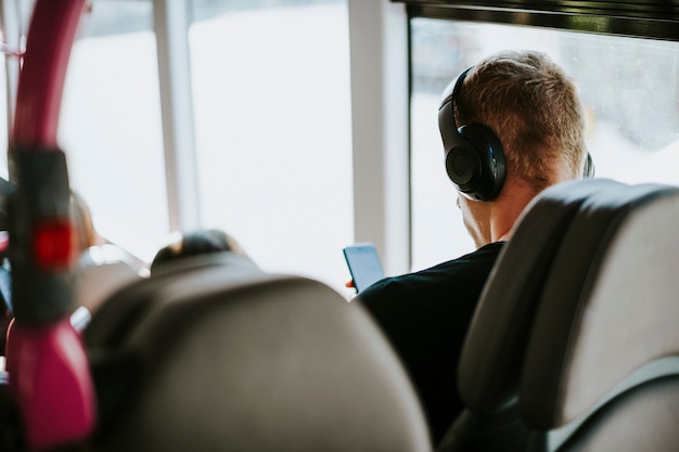 Foto gratuita hombre escuchando música en un autobús.