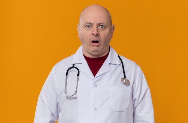 Hombre eslavo adulto sorprendido en uniforme médico con estetoscopio mirando al frente