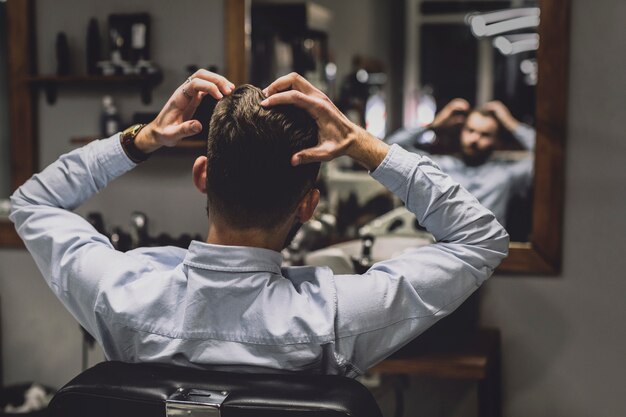 Hombre en espejo en barbería