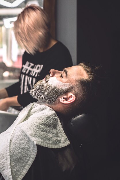 Hombre con espuma en la cara en la barbería