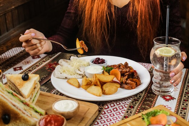 El hombre está comiendo patatas fritas con pollo y verduras