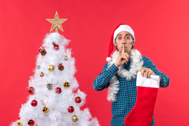 Un hombre está de pie junto al árbol de Navidad.