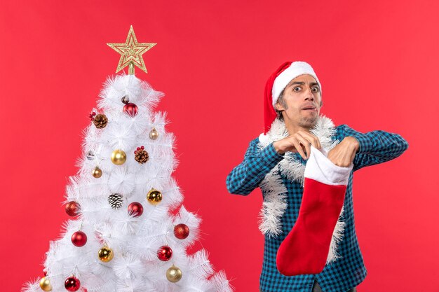 Un hombre está de pie junto al árbol de Navidad.