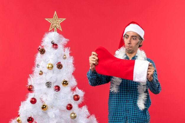 Un hombre está de pie junto al árbol de Navidad.