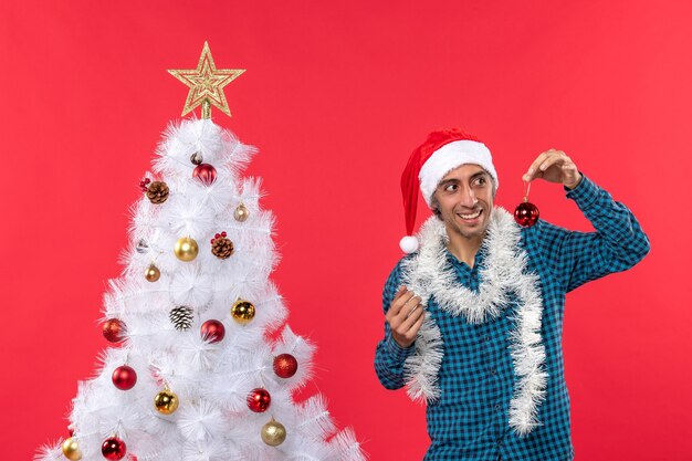 Un hombre está de pie junto al árbol de Navidad.