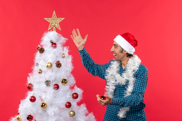 Un hombre está de pie junto al árbol de Navidad.