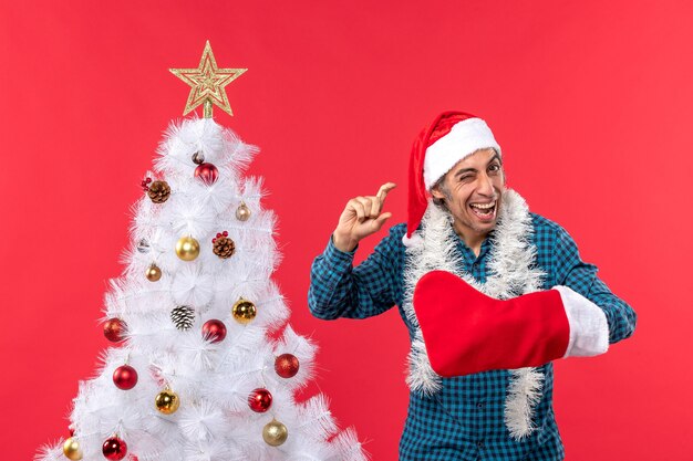 Un hombre está de pie junto al árbol de Navidad.