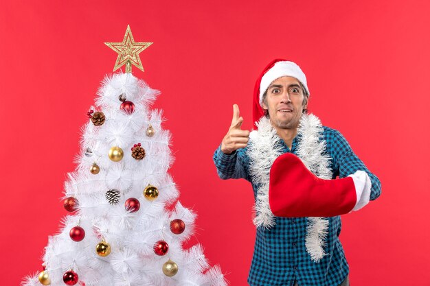 Un hombre está de pie junto al árbol de Navidad.