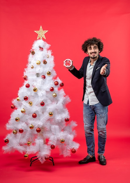 Un hombre está de pie junto al árbol de Navidad.