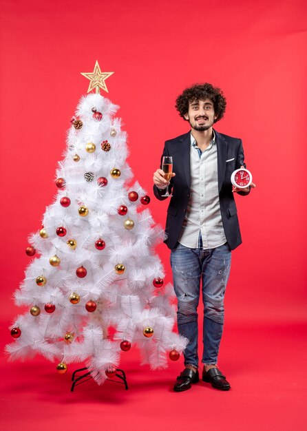 Un hombre está de pie junto al árbol de Navidad.