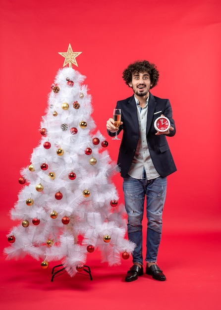 Un hombre está de pie junto al árbol de Navidad.