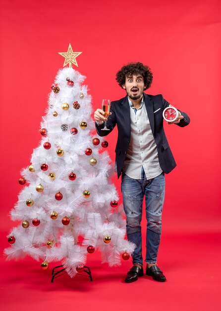 Un hombre está de pie junto al árbol de Navidad.