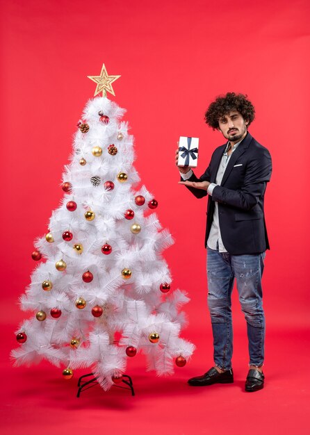 Un hombre está de pie junto al árbol de Navidad.