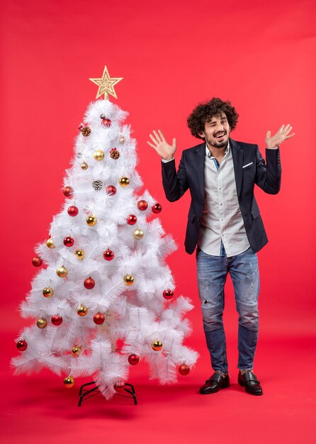 Un hombre está de pie junto al árbol de Navidad.