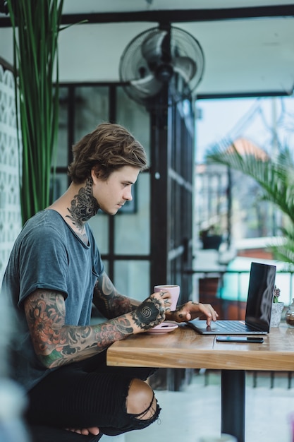 el hombre está trabajando en un café. concepto de trabajo independiente, café y computadora portátil
