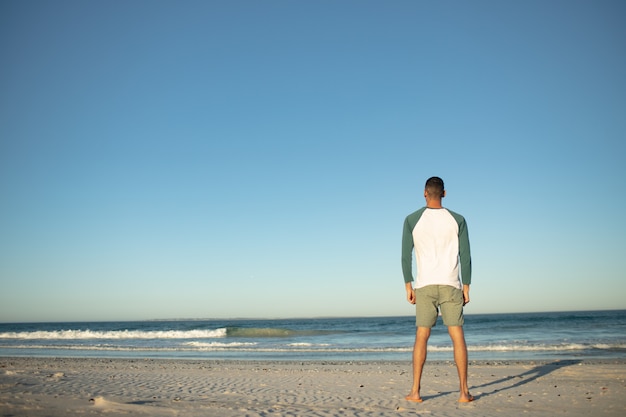 Hombre estar de pie, en la playa