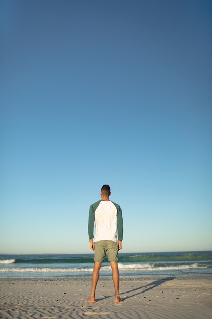 Hombre estar de pie, en la playa