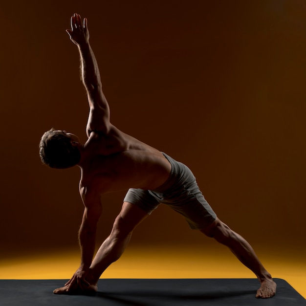 Hombre en la estera de yoga haciendo ejercicio