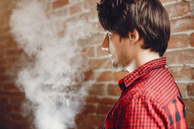 Foto gratuito hombre con estilo y elegante en una ciudad con vape