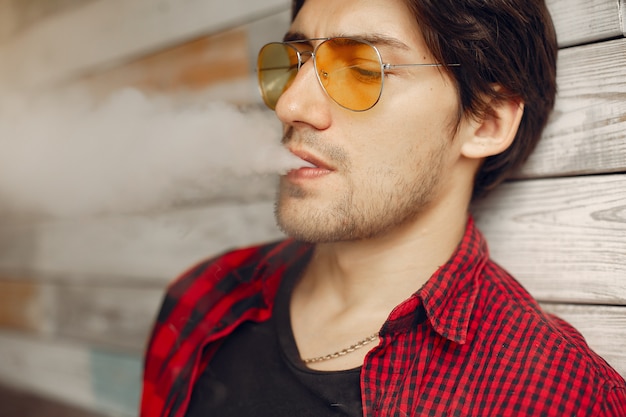 Foto gratuita hombre con estilo y elegante en una ciudad con vape