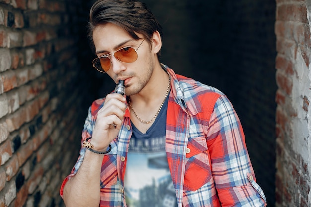 Hombre con estilo y elegante en una ciudad con vape