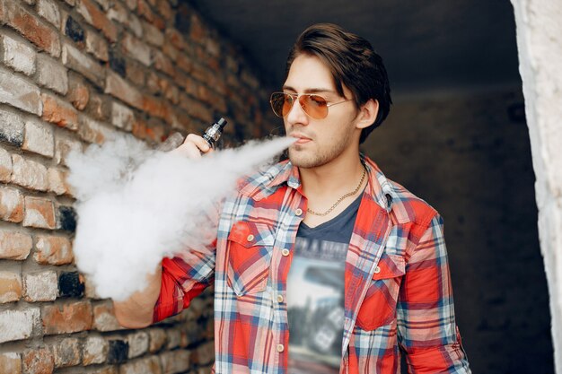 Hombre con estilo y elegante en una ciudad con vape