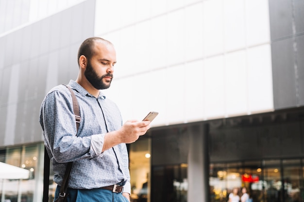 Hombre con estilo con teléfono inteligente en la calle