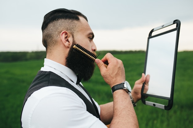 Foto gratuita hombre estiloso peinándose la barba