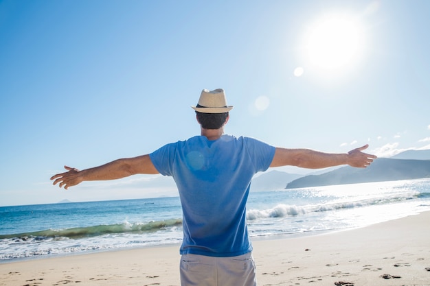 Foto gratuita hombre estirando los brazos en la playa