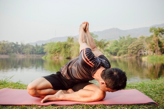 Foto gratuita hombre estirando la espalda al lado del lago