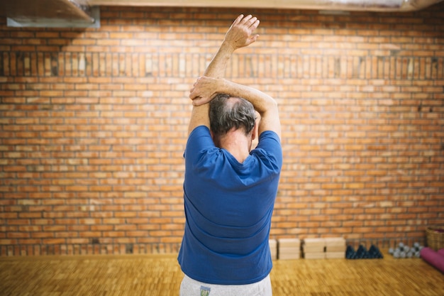 Hombre estirando en gimnasio