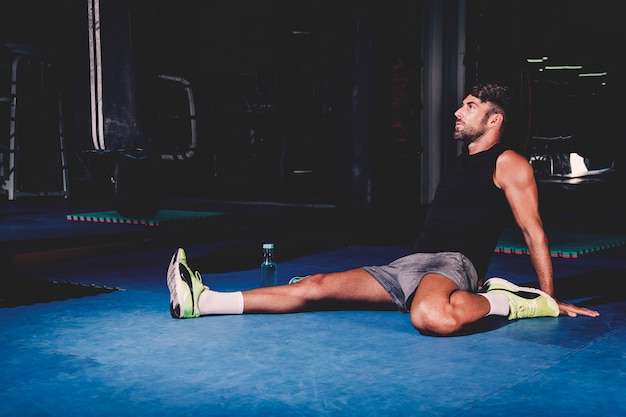 Foto gratuita hombre estirando en gimnasio