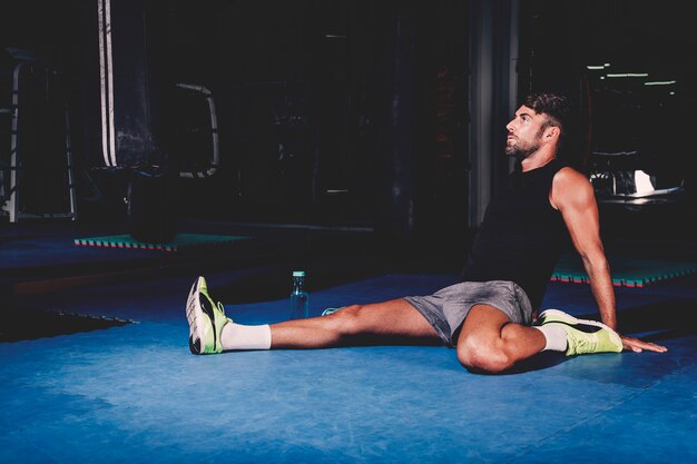 Hombre estirando en gimnasio